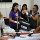 Women learn how to make a DIY washing machine with plastic buckets.